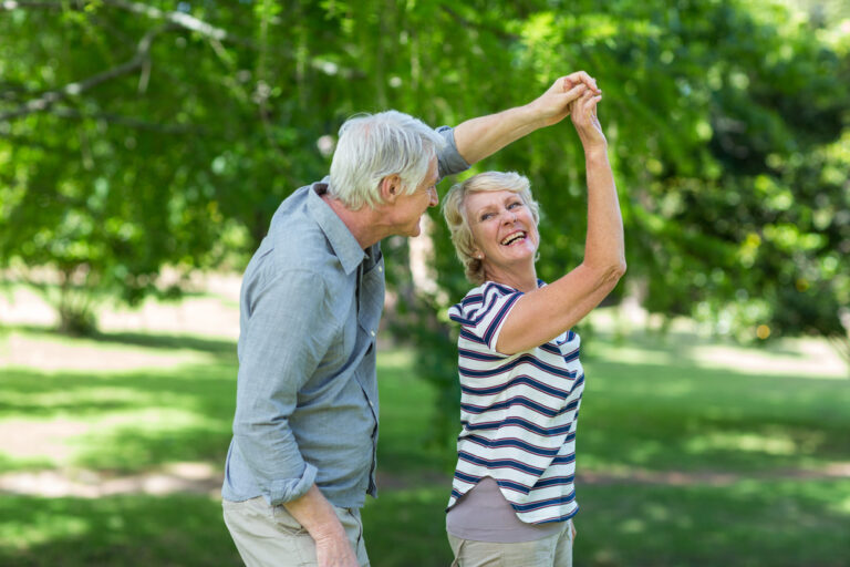 Happy senior couple with beautiful smiles from dentures outdoors