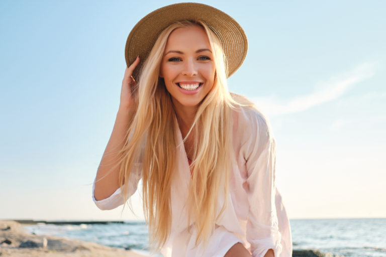 Woman smiling with white teeth from getting her teeth whitened from a dentist