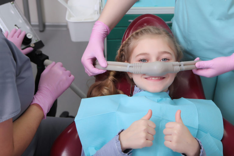 Little girl with thumbs up with dental sedation in Anchorage