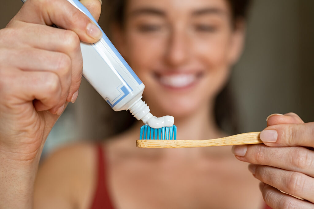 woman putting some toothpaste on her toothbrush